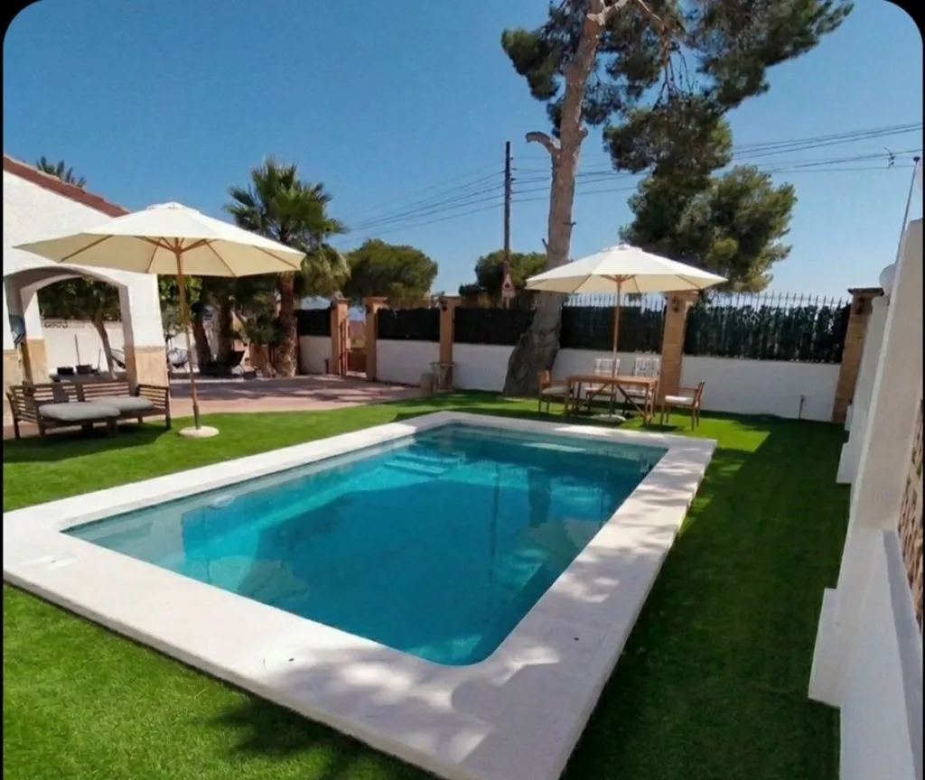 Piscina privada y jardín de Villa Carolina en Punta Prima